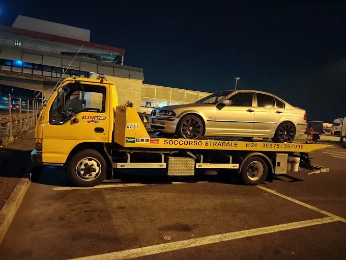 Carro attrezzi Ion Service di notte con un'auto caricata sul pianale